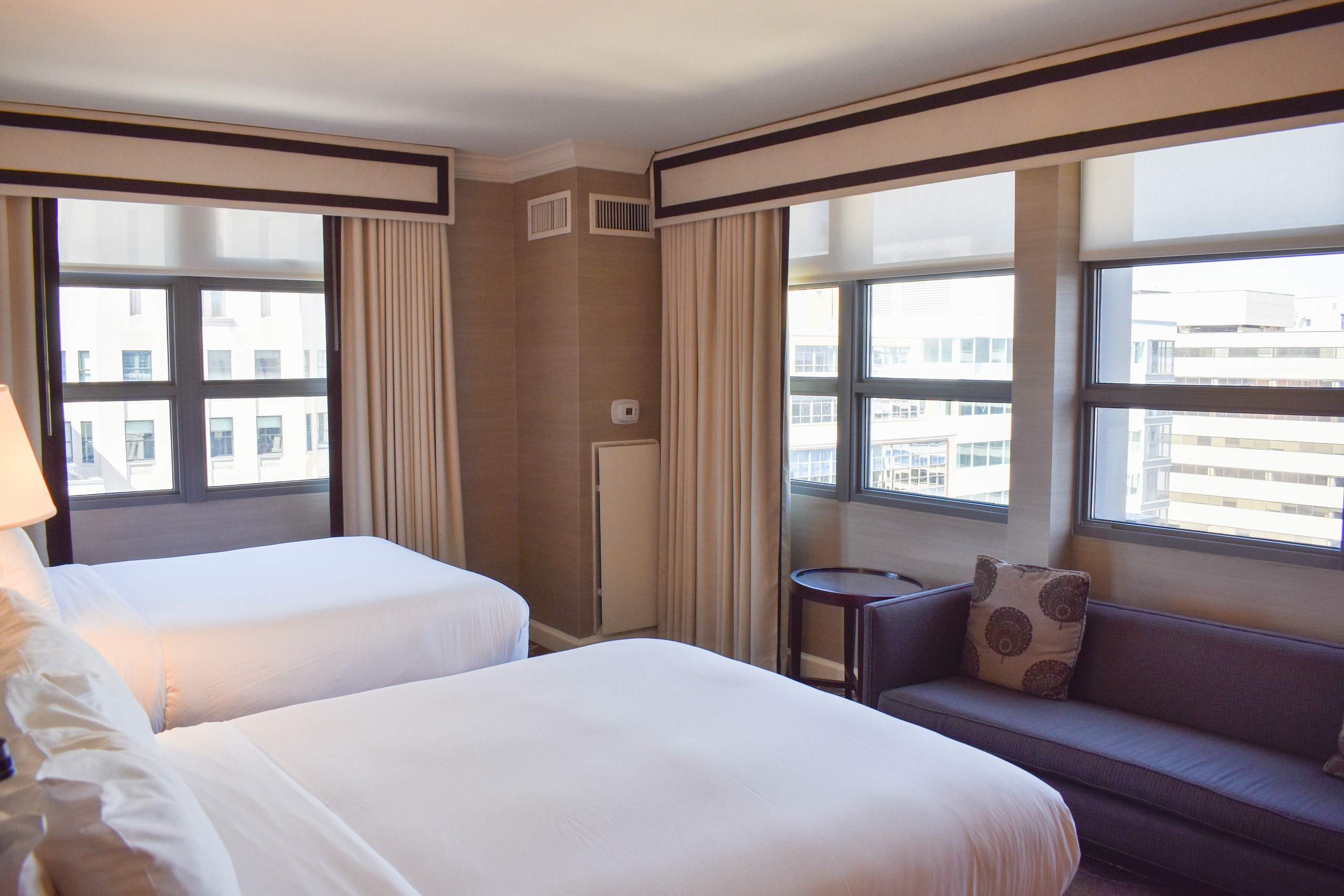 Double beds beside windows and sofa.