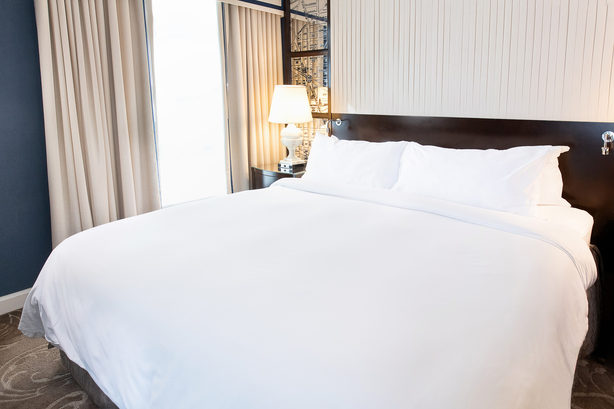 King bedroom at Hamilton Hotel DC with luxury bedding and oversized windows