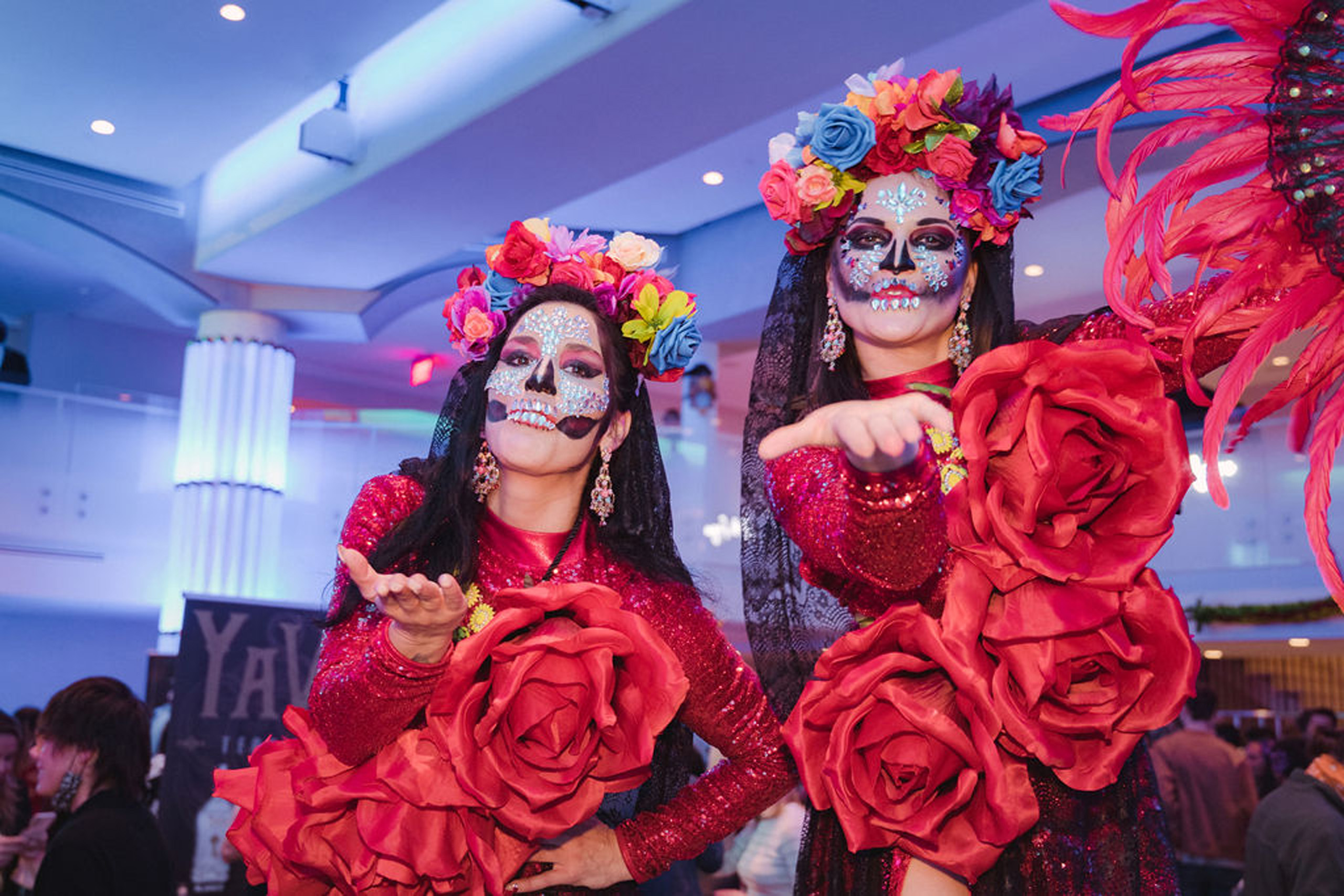 Festive performers in vibrant Día de los Muertos attire.