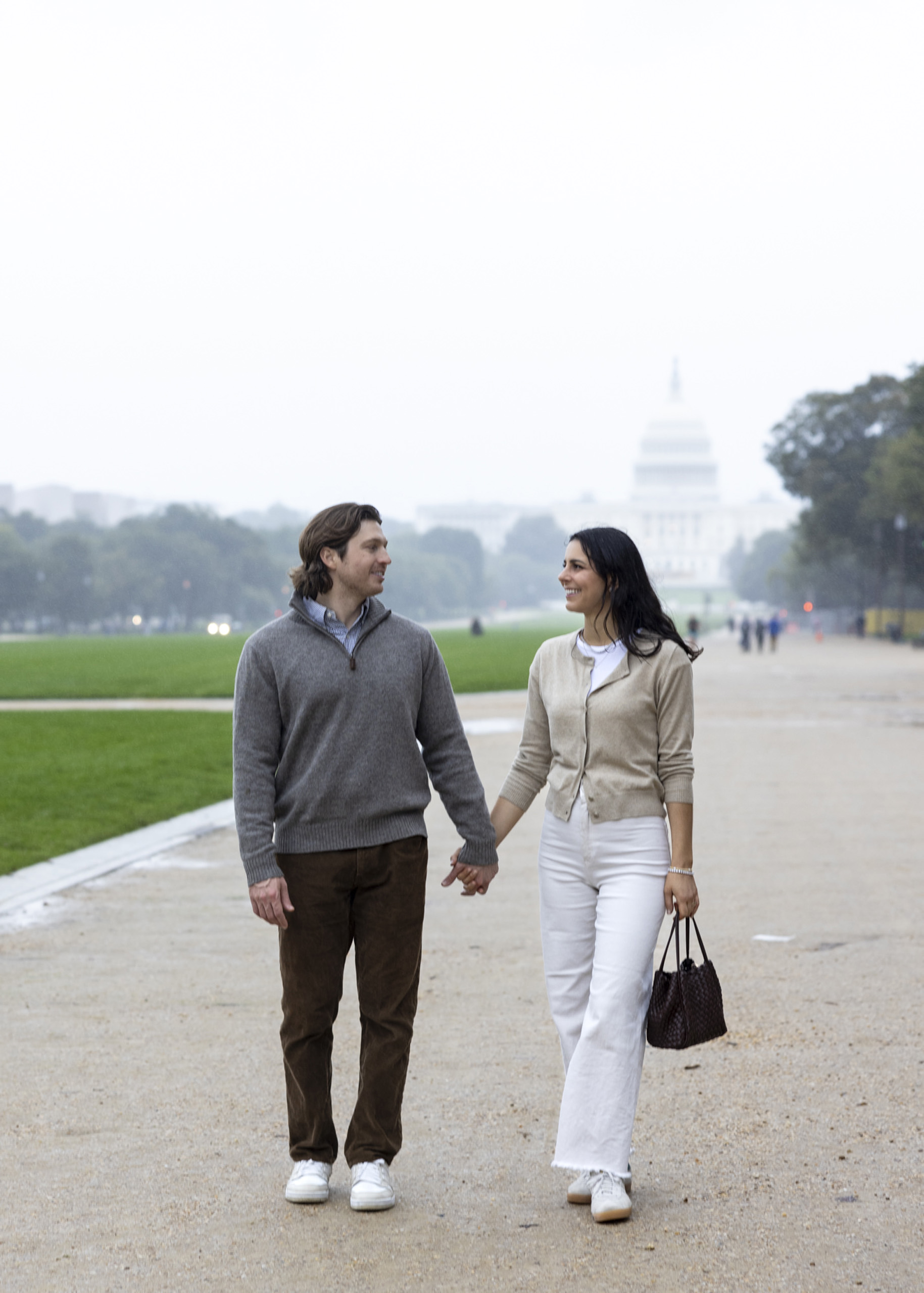 Couple walking near U.S. Capitol at dawn.