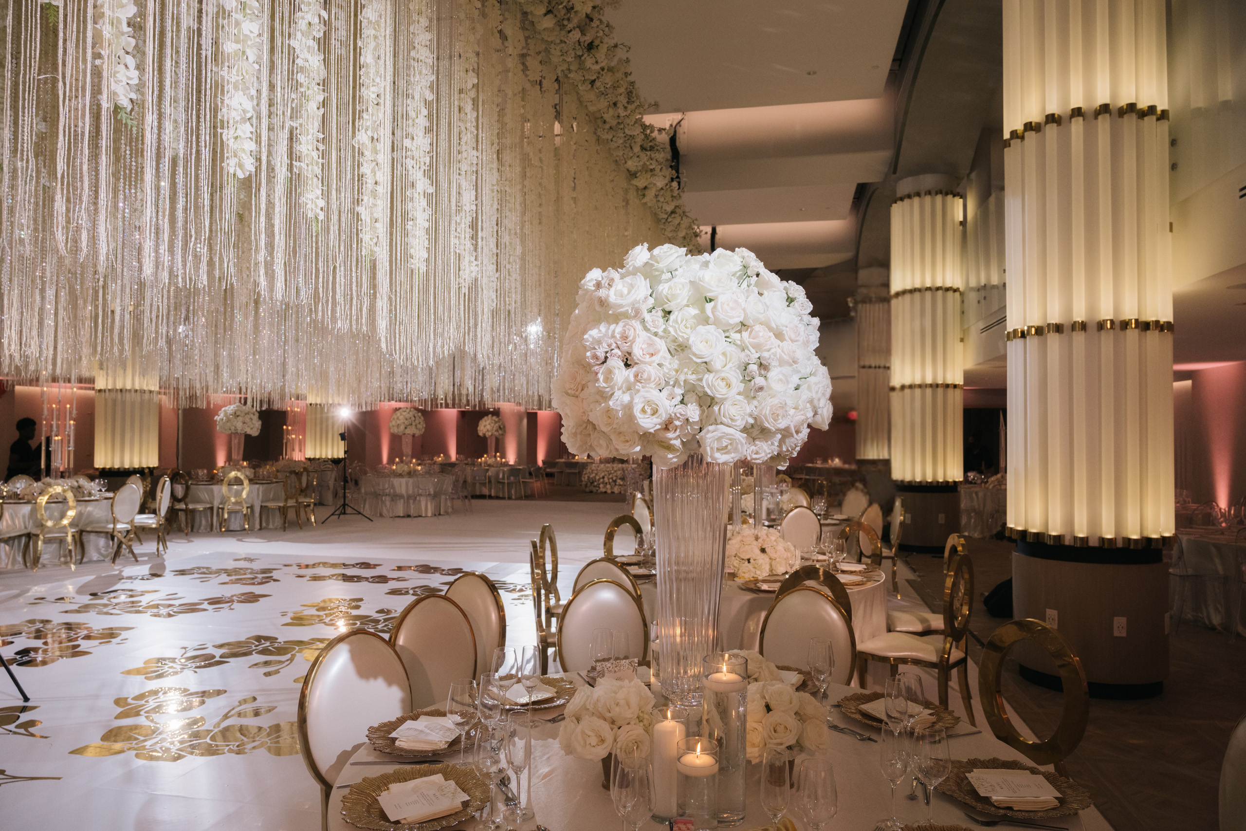 Elegant ballroom wedding with white floral centerpieces.