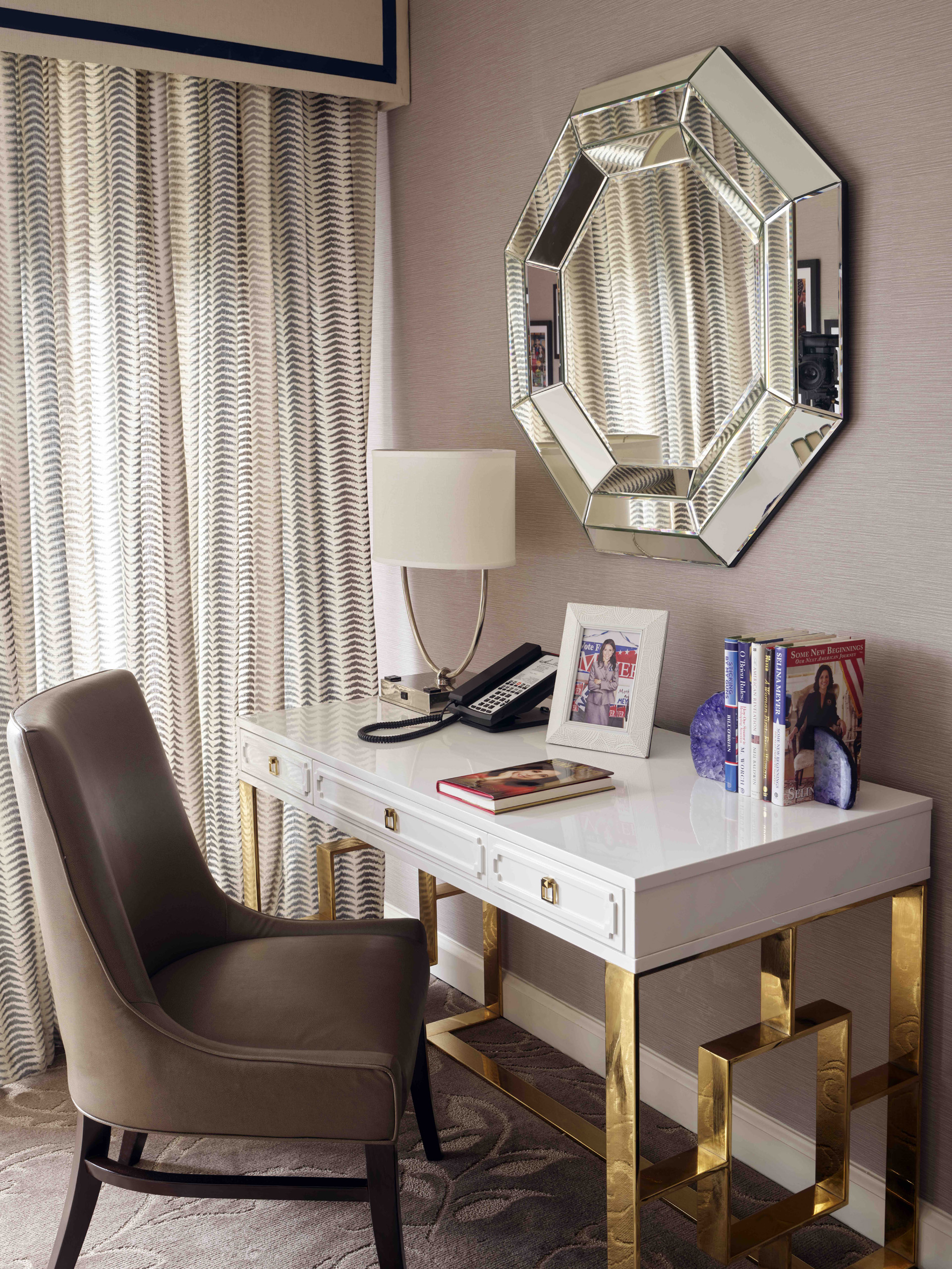 Chic desk beneath mirrored wall accent.