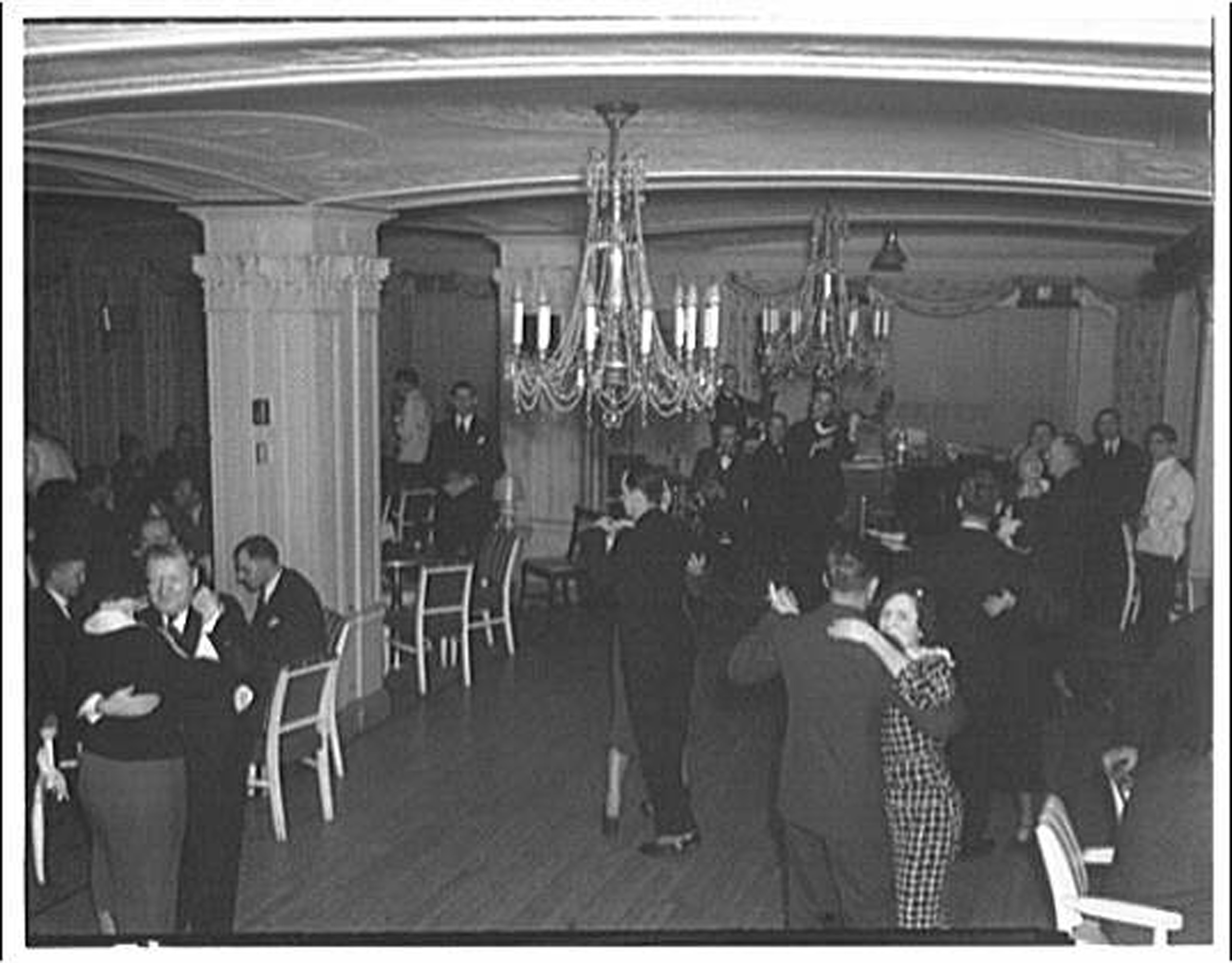 Couples dancing in vintage ballroom.