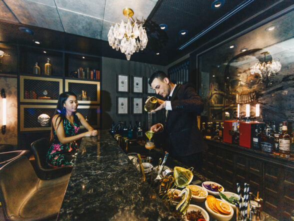 Bartender crafting cocktail at intimate lounge bar