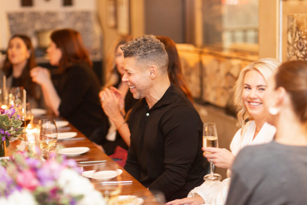 Friends enjoying dinner and champagne at long table