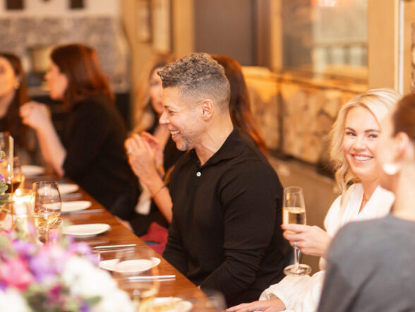 Friends enjoying dinner and champagne at long table