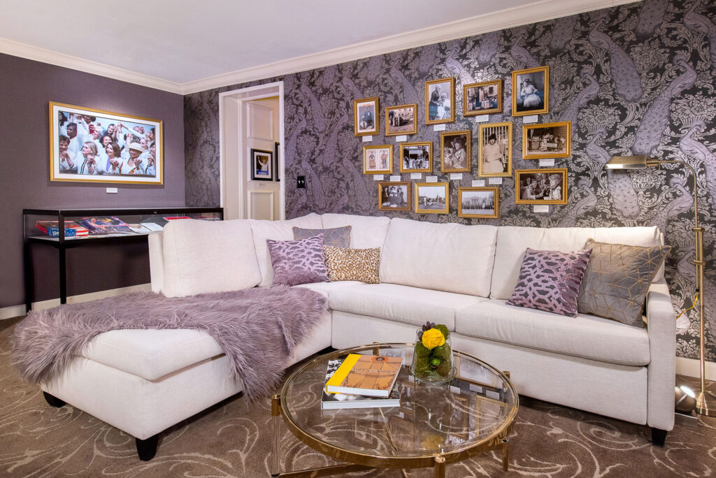 Spacious lounge with sectional and gold frames.