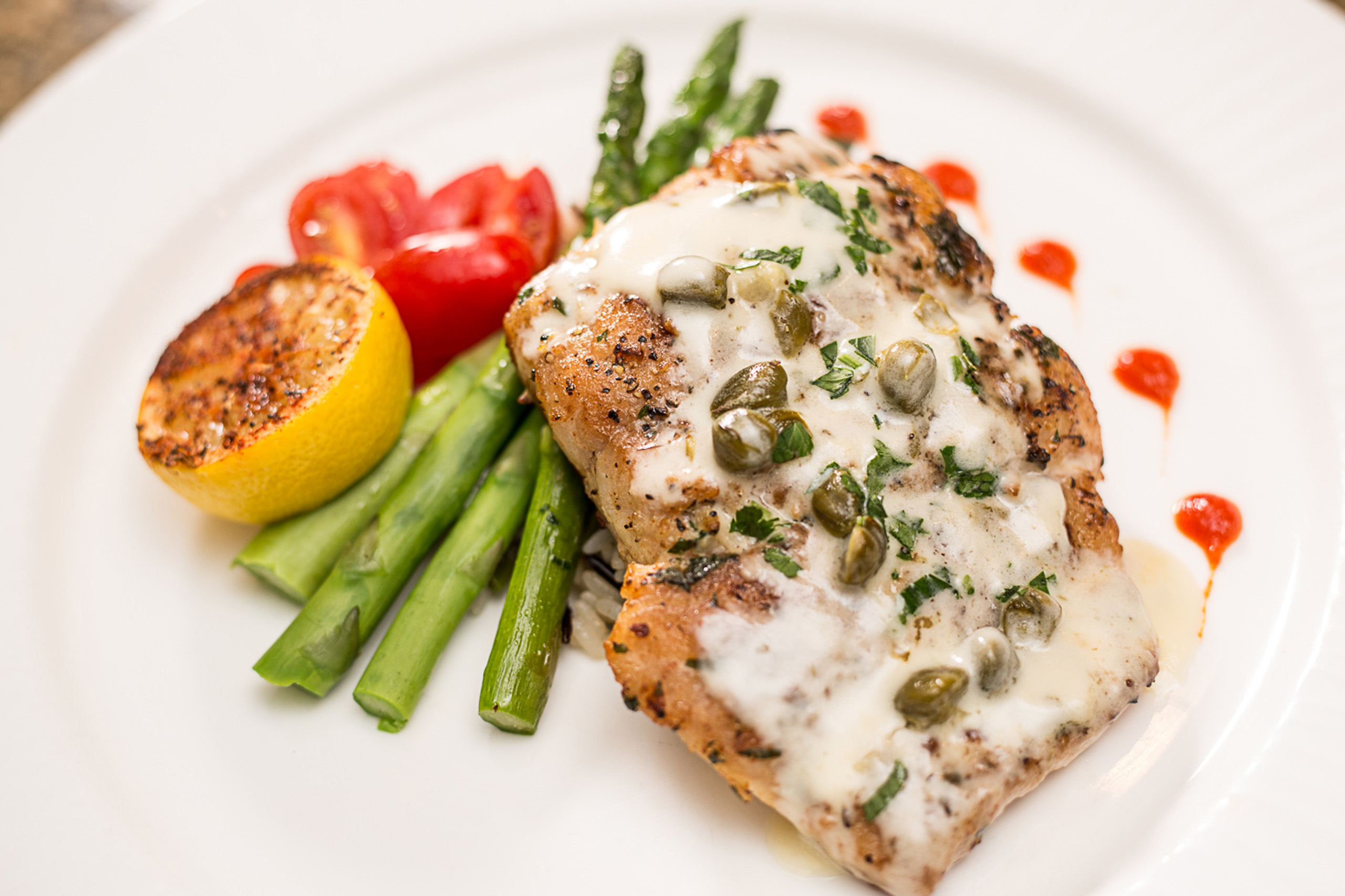 Grilled salmon with asparagus, lemon, and capers.