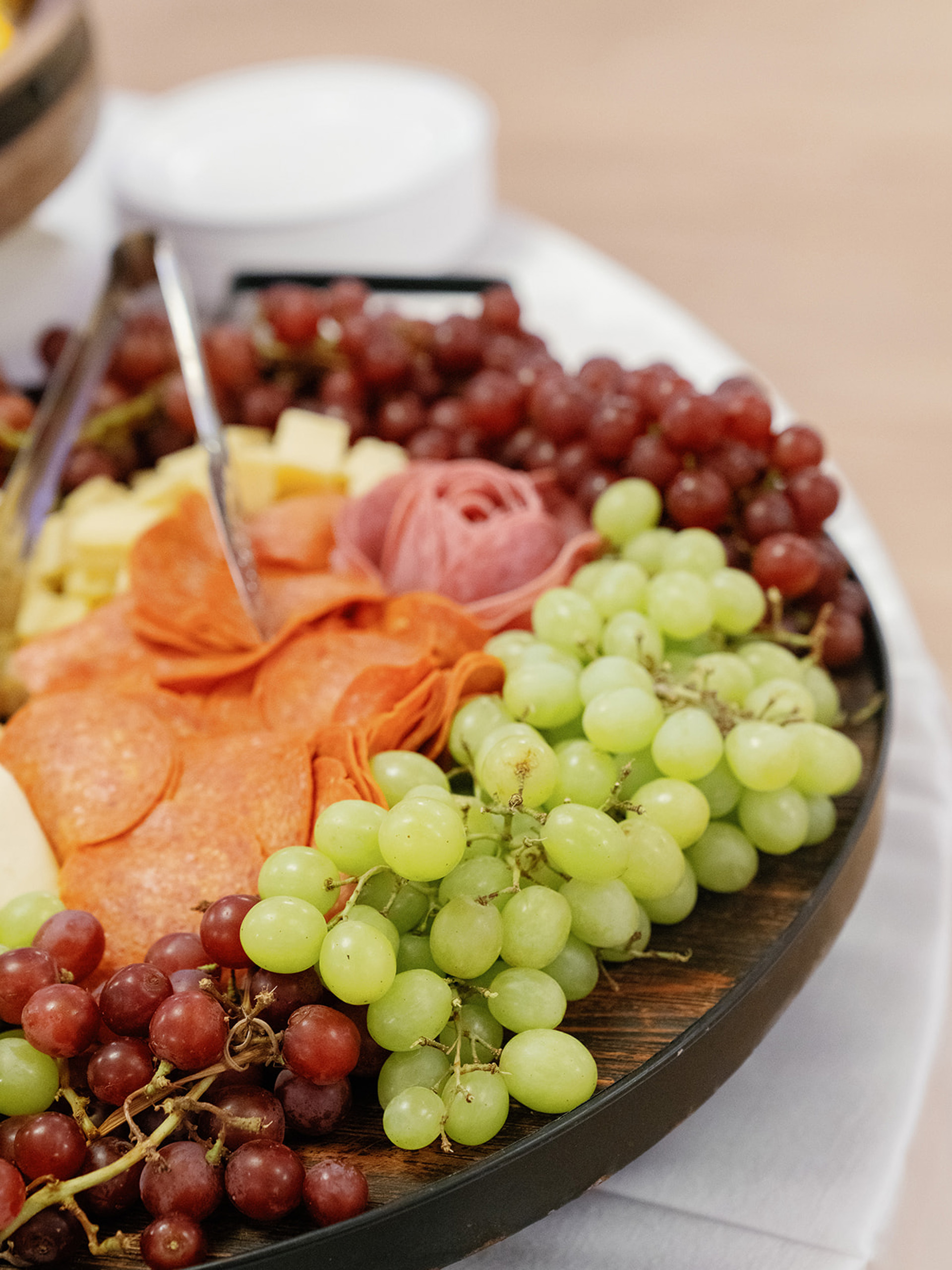 Charcuterie board with grapes, cheeses, and cured meats.