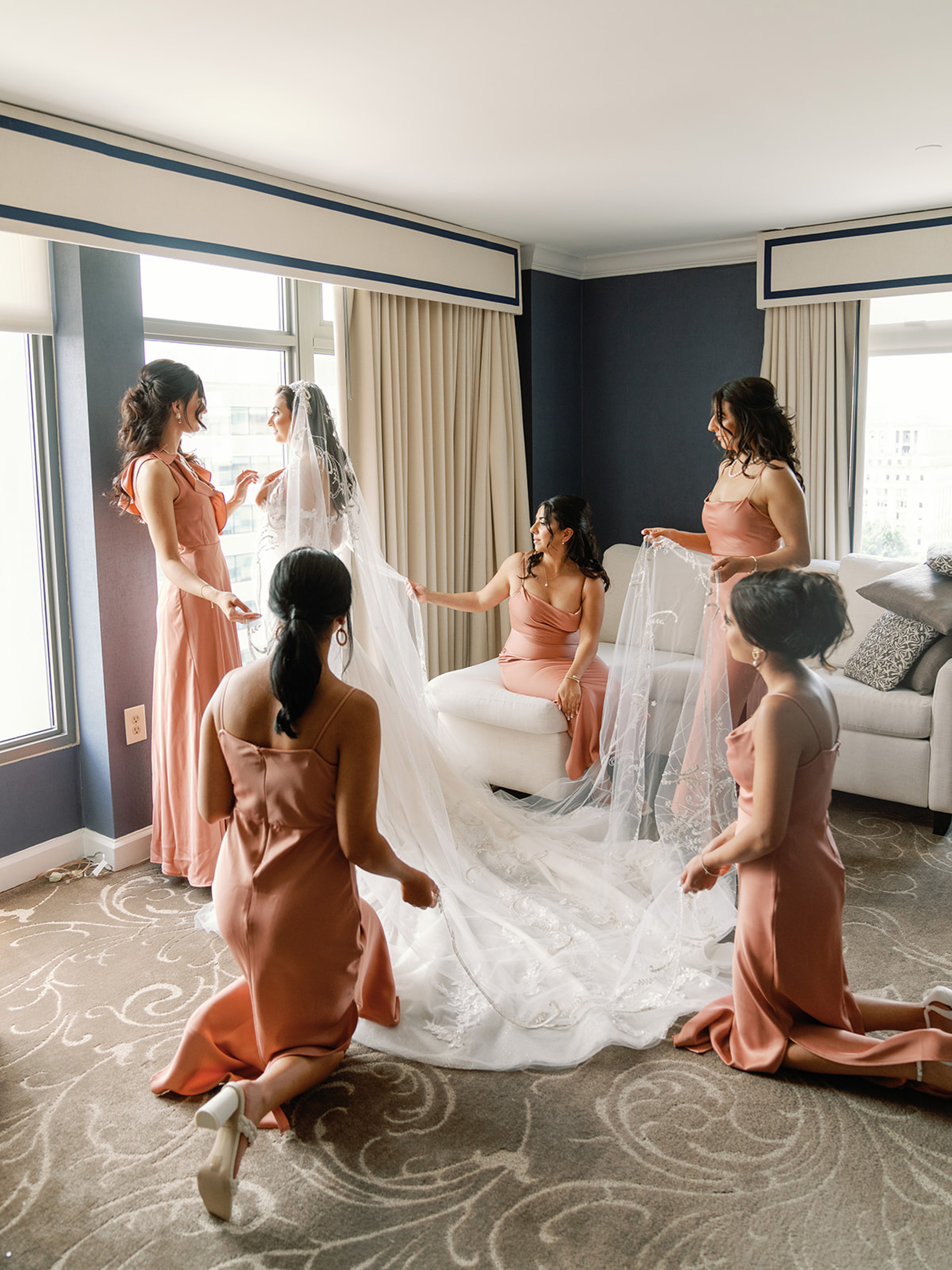 Bride with bridesmaids adjusting veil.