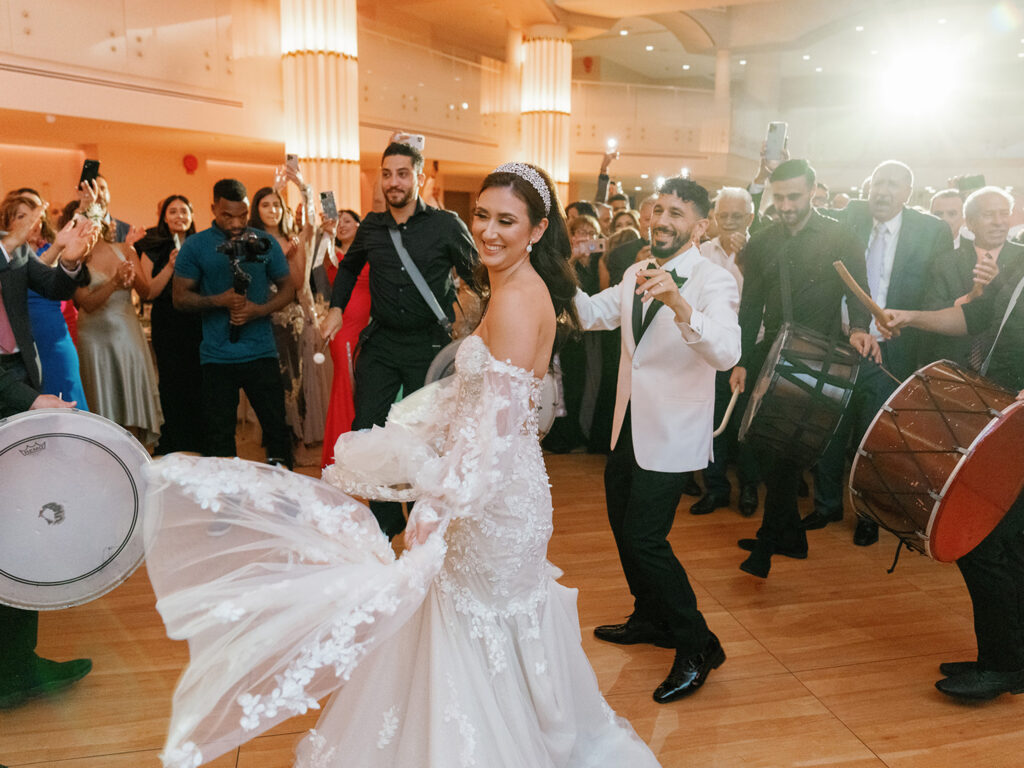 Bride dancing with drummers at reception.