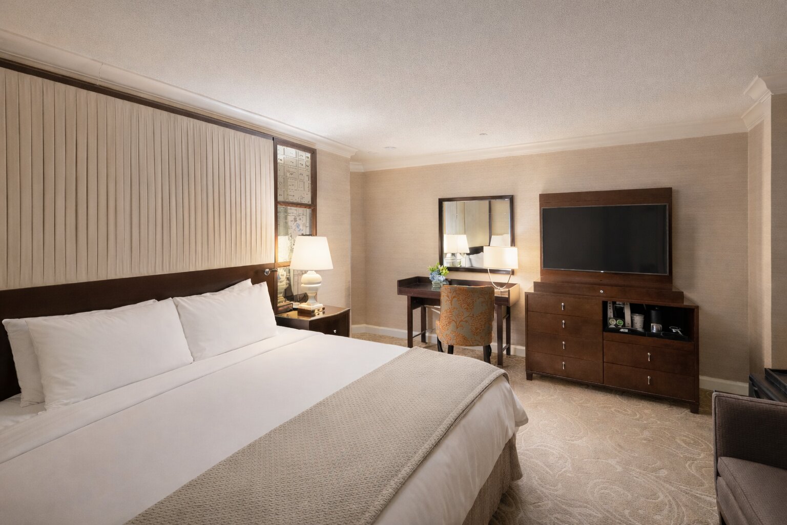 King bedroom with desk and television.