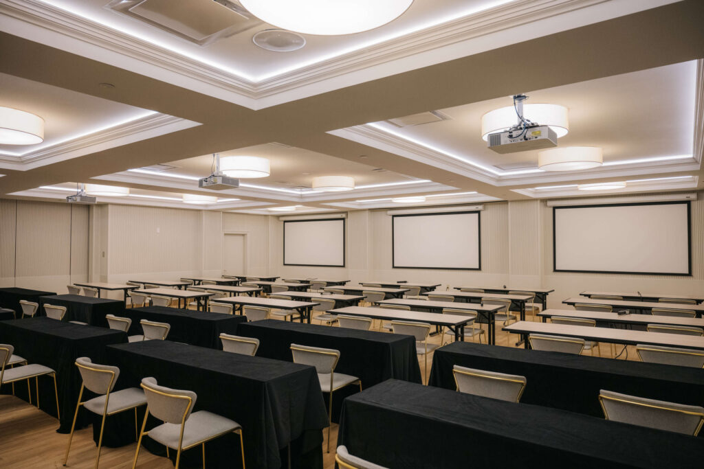 meeting room set up with horizontal rows of tables and chairs