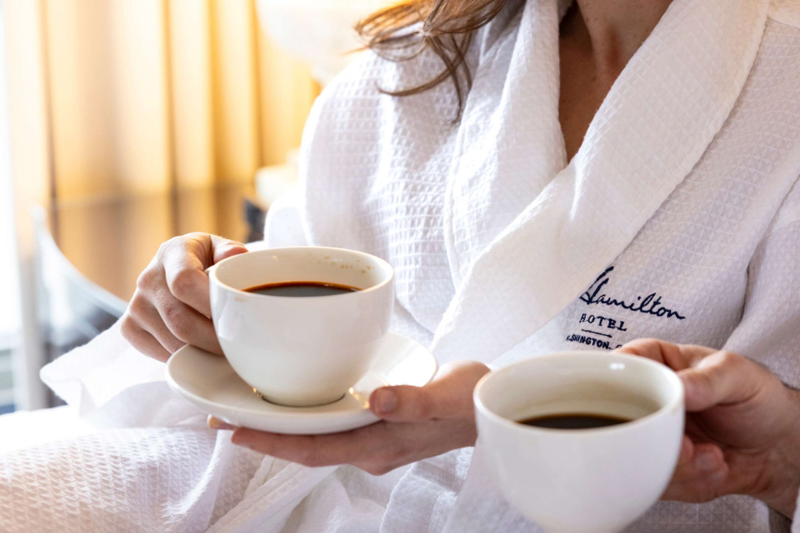 woman drinking coffee in bed with monogrammed hamilton bathrobe