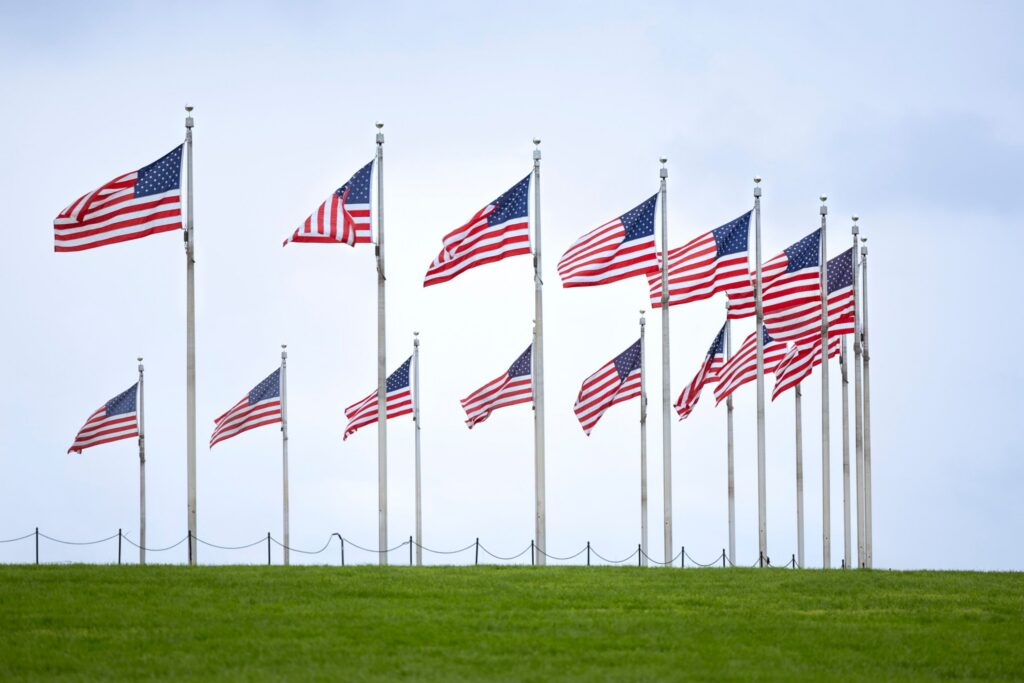 horseshoe arrangement of American flags on green field