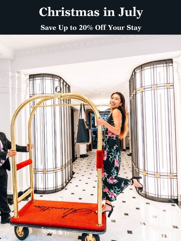 Guest smiles while riding luggage cart through Hamilton Hotel lobby.