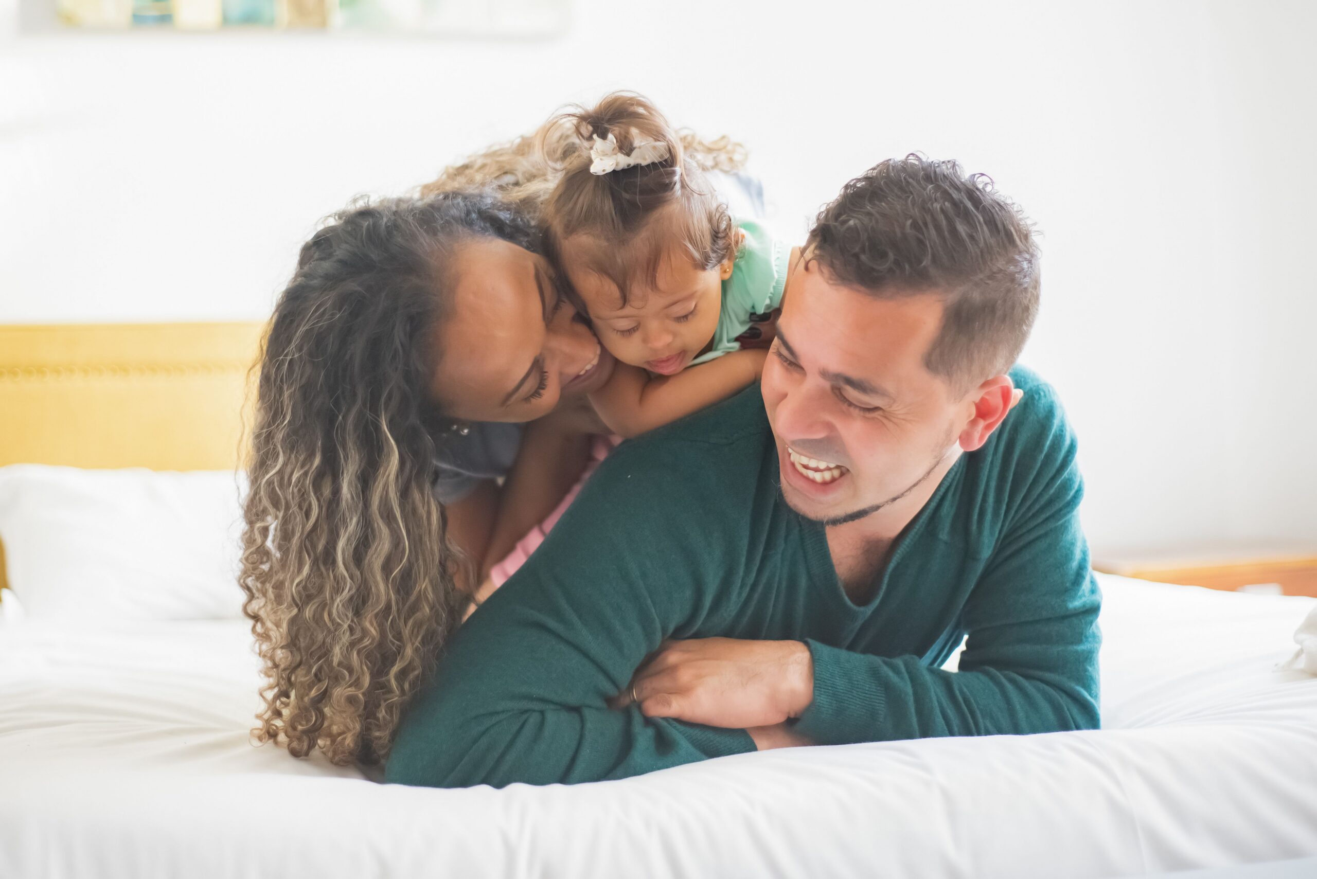 family laying on a bed