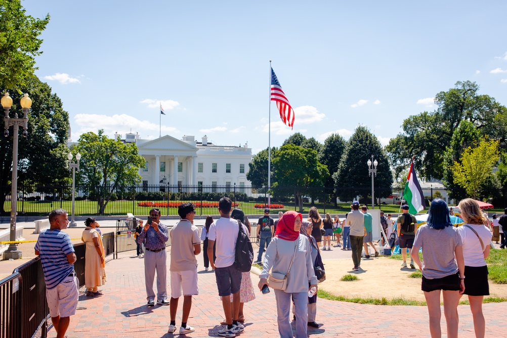 Groups of people stood looking and taking pictures of the white house